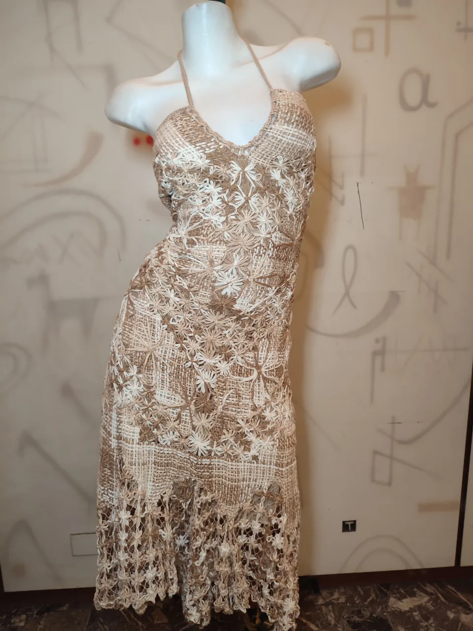 Vestido largo de tejido artesanal con detalles florales en relieve. Posee tiras finas para atar en el cuello y espalda descubierta con tiras cruzadas.Unico en su estilo, todo forrado ,el talle es regulable va del M al L ya que se ajusta toda la espada y la cintura 