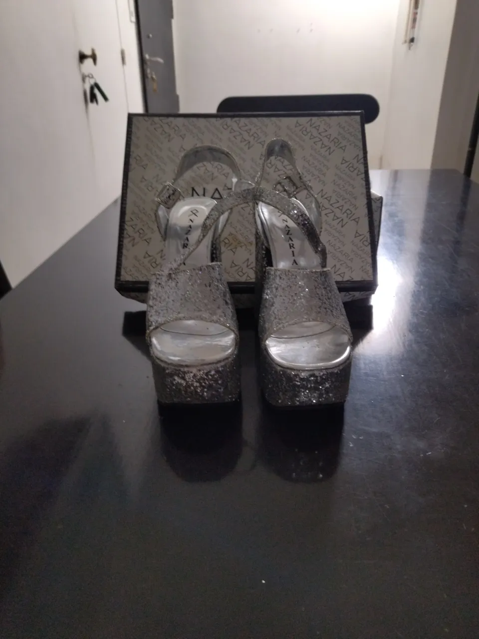 Sandalias plateadas con glitter y taco alto. Tienen pulsera y plataforma.