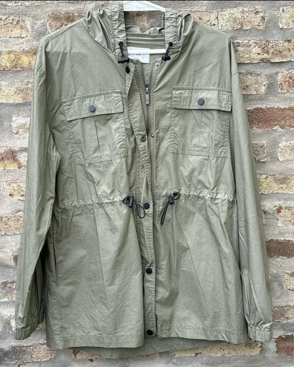 Campera verde militar con capucha y bolsillos. Ideal para un look casual y cómodo. Cuenta con ajuste en la cintura y capucha con cordones. Talle 42. med: largo 74 cm/sisa a sisa 59 cm/ manga 61 cm