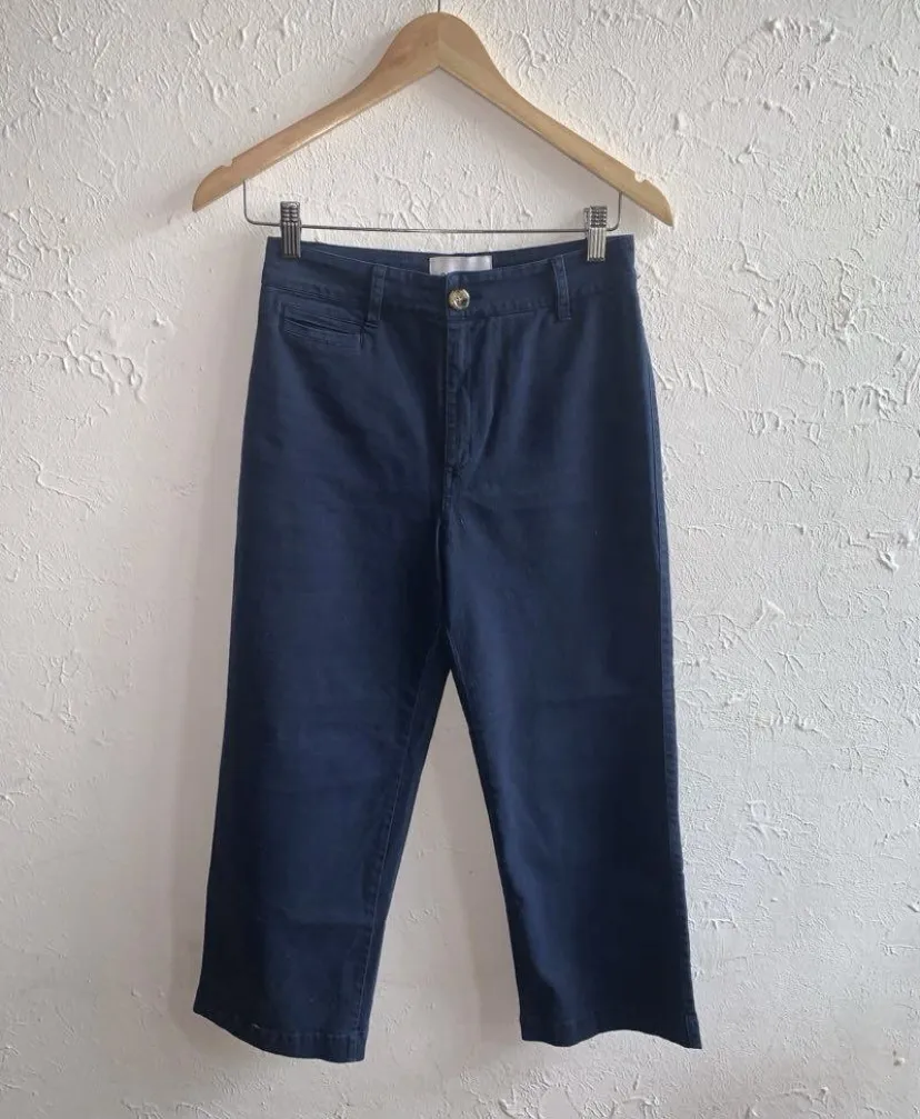 Pantalón azul marino de gabardina, con bolsillos delanteros y traseros. Cierre y botón en la parte delantera.