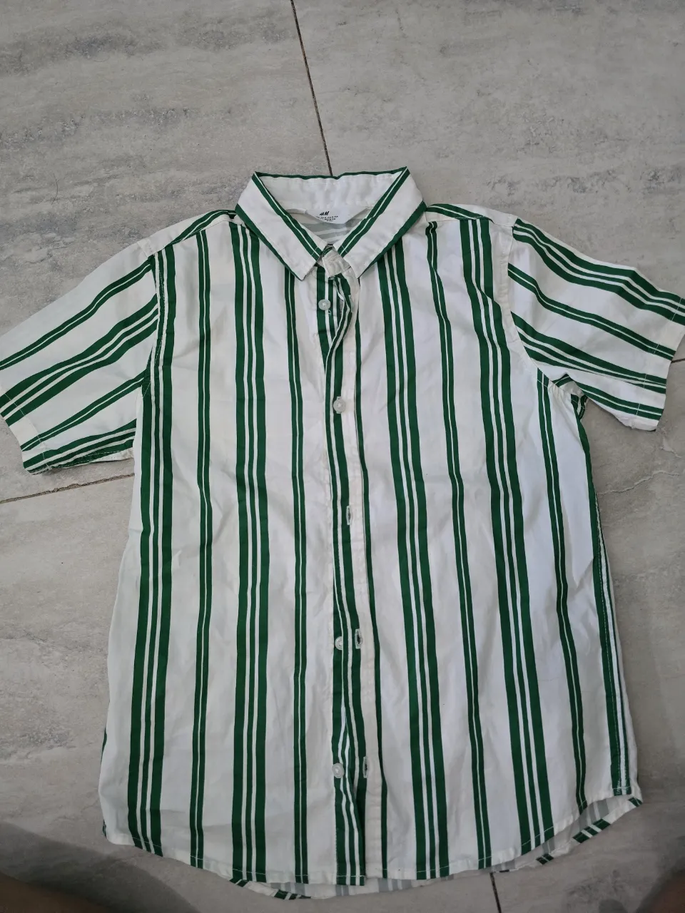 Camisa a rayas blancas y verdes, manga corta, ideal para un look casual y fresco. Perfecta para los días de sol.