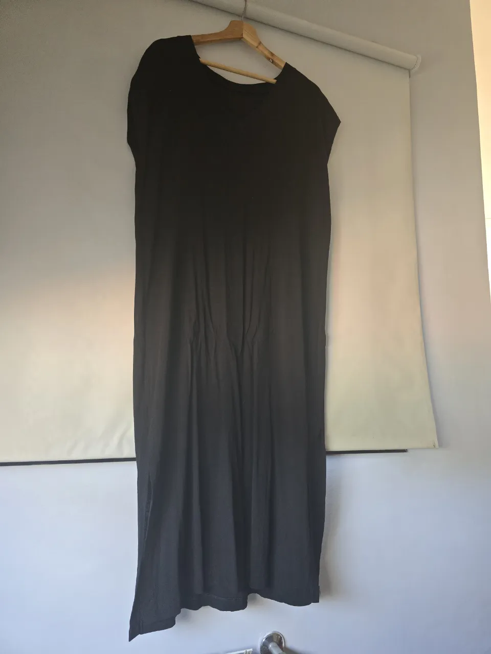 Vestido negro largo, tipo túnica con escote en V y mangas cortas. Ideal para un look casual y cómodo.