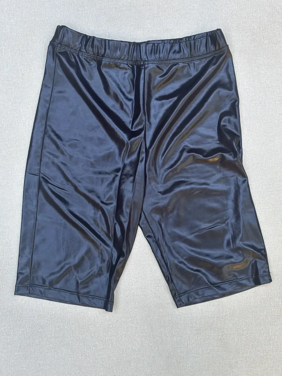 Shorts de cuero sintético negro, tiro alto, con elástico en la cintura. Ideales para un look canchero y moderno.