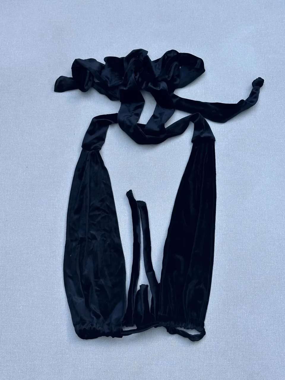 Top de terciopelo negro con tiras para atar. Ideal para un look audaz y sensual.