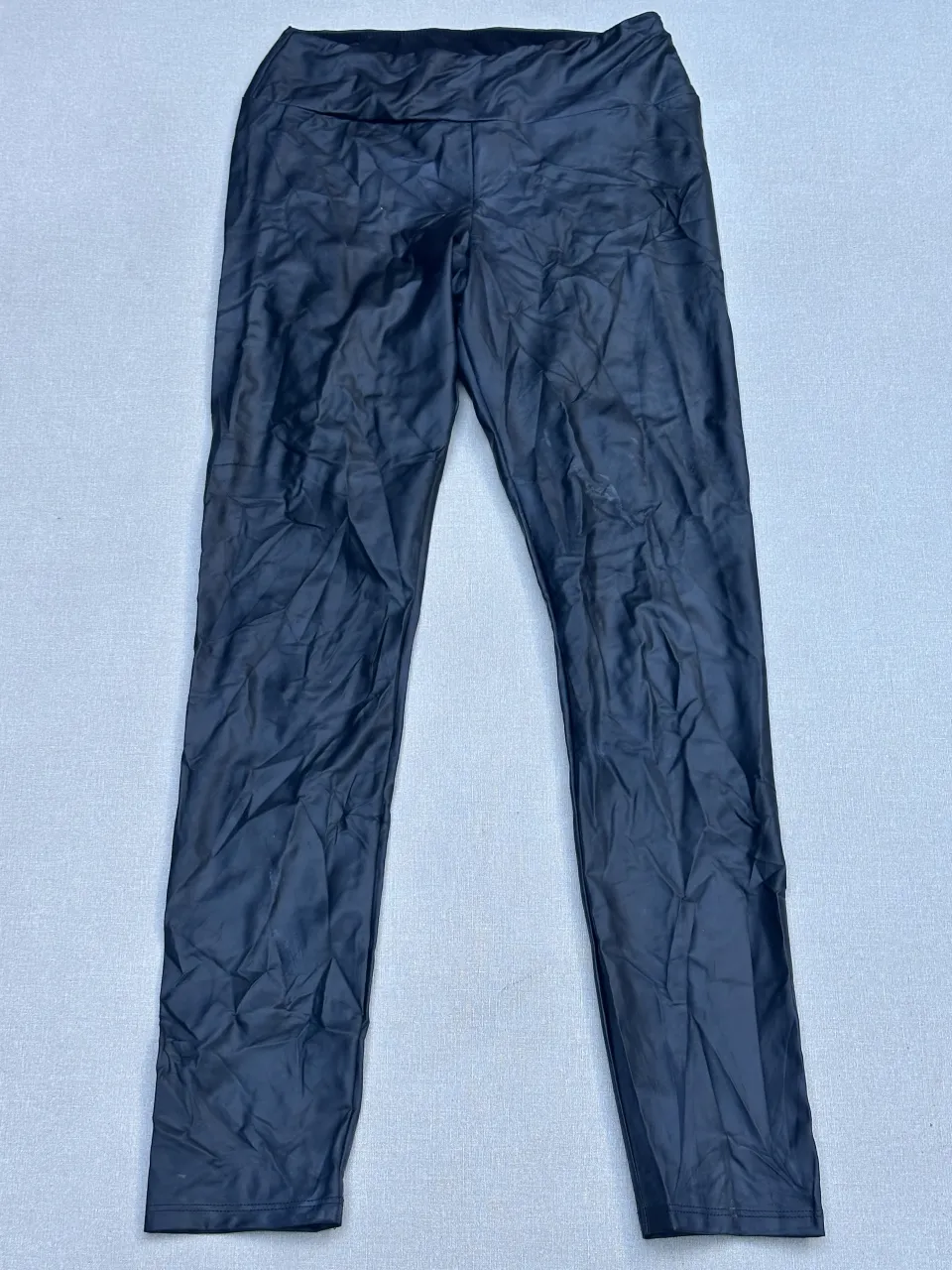 Calzas negras efecto cuero, tiro alto, ideales para un look canchero y moderno. Perfectas para combinar con buzos o tops.