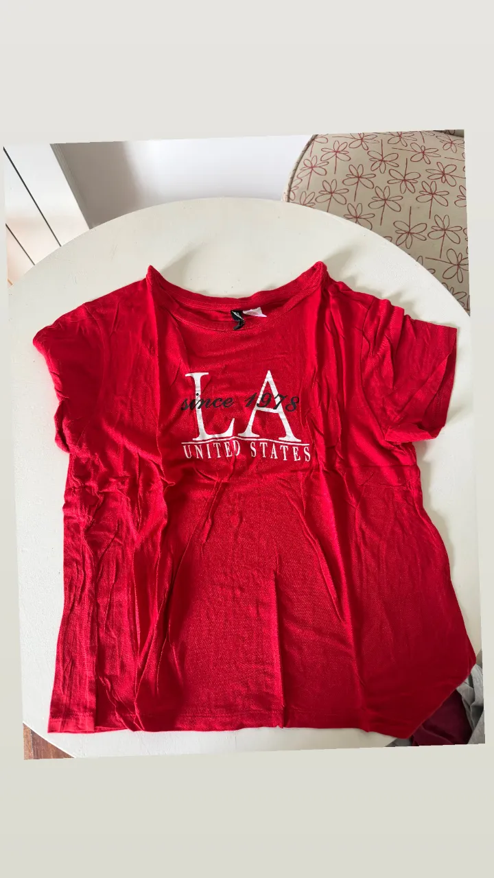 Remera roja con estampa "LA United States" en blanco. Ideal para un look casual y urbano.