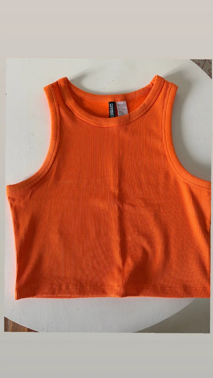 Musculosa naranja acanalada, súper canchera y cómoda. Ideal para un look casual y fresco.