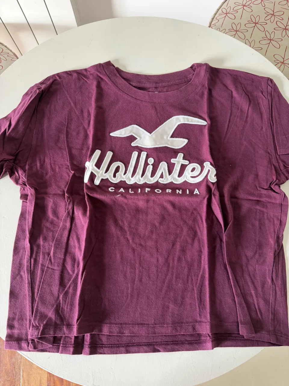 Remera de algodón color bordó con estampa de Hollister California. Ideal para un look casual y relajado.