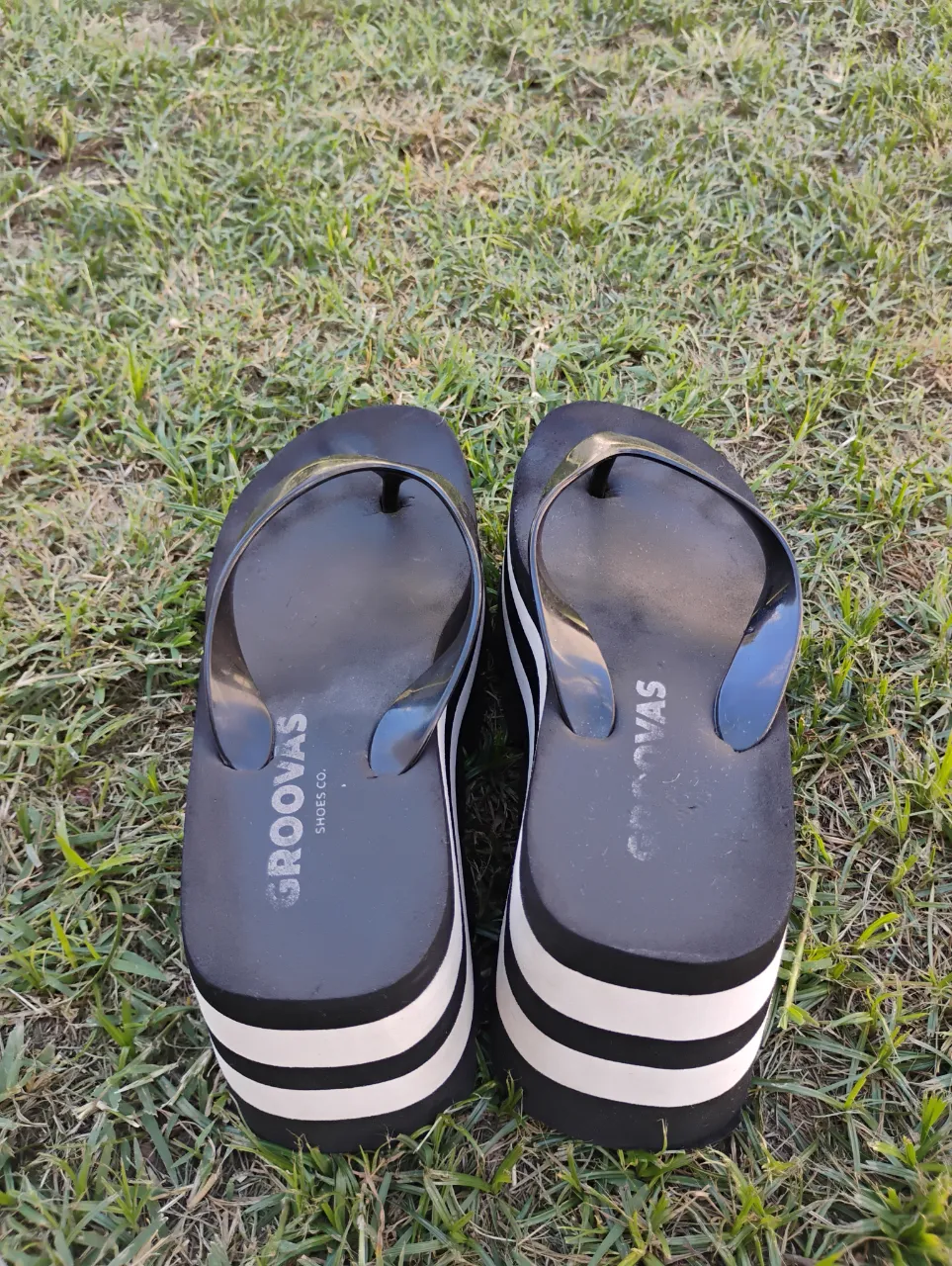 Ojotas negras con plataforma a rayas blancas y negras. Marca Groovas.