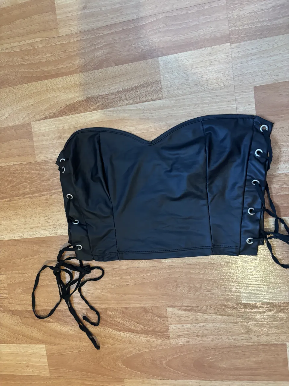 Top negro strapless con cordones en los laterales.