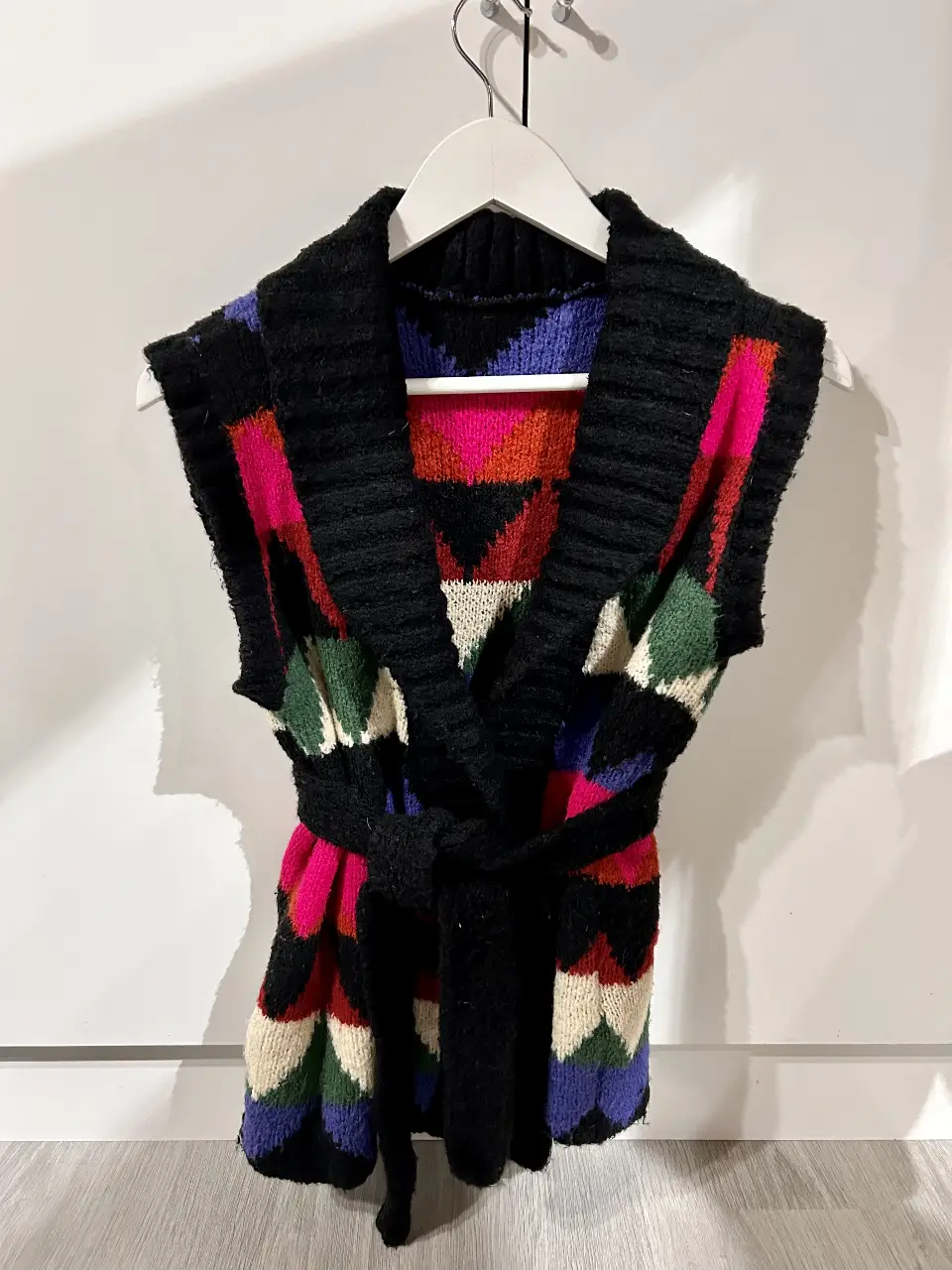 Chaleco tejido sin mangas con diseño geométrico en tonos vibrantes. Ideal para un look bohemio y con estilo.