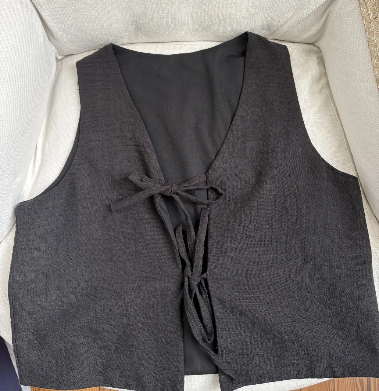 Chaleco negro con lazos en la parte delantera.