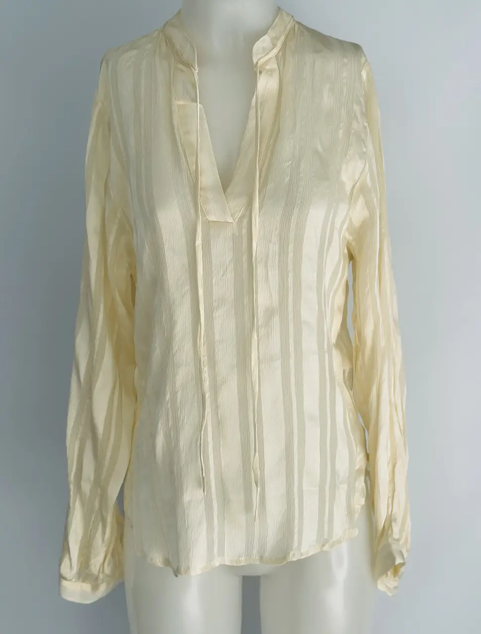 Blusa de seda con diseño a rayas verticales, cuello en V y mangas largas. Ideal para un look elegante y sofisticado.