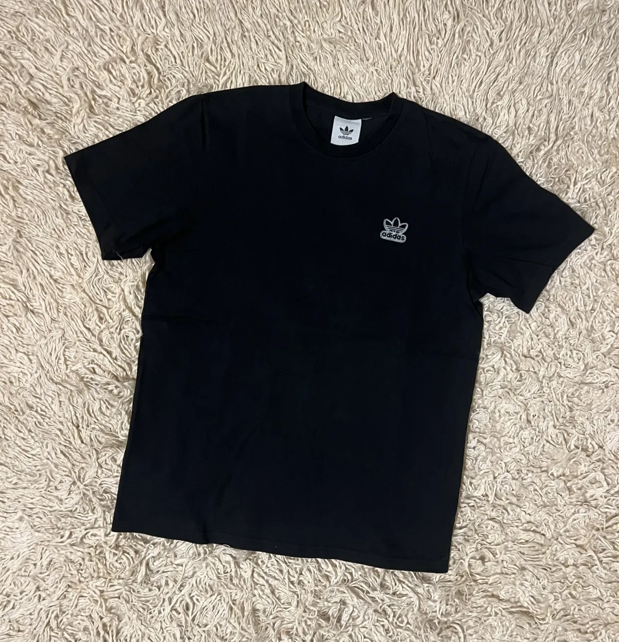 Remera negra de manga corta con logo de Adidas bordado en el pecho. Sisa 53 Cm - Largo 71 Cm 