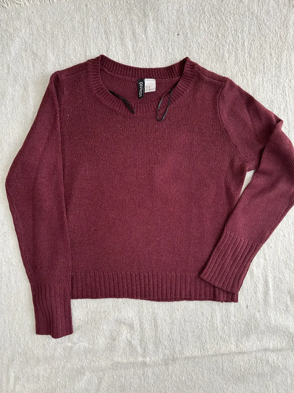 Sweater de mujer color borgoña, tejido de acrílico, ideal para el invierno. Cuello redondo y puños tejidos.