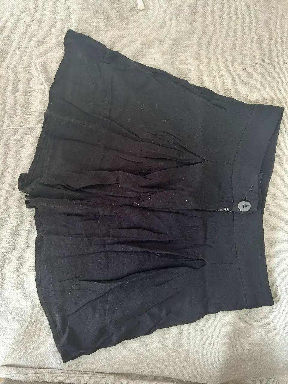 Short negro de tiro alto, ideal para un look casual y moderno. Perfecto para combinar con diferentes tops y crear outfits versátiles.