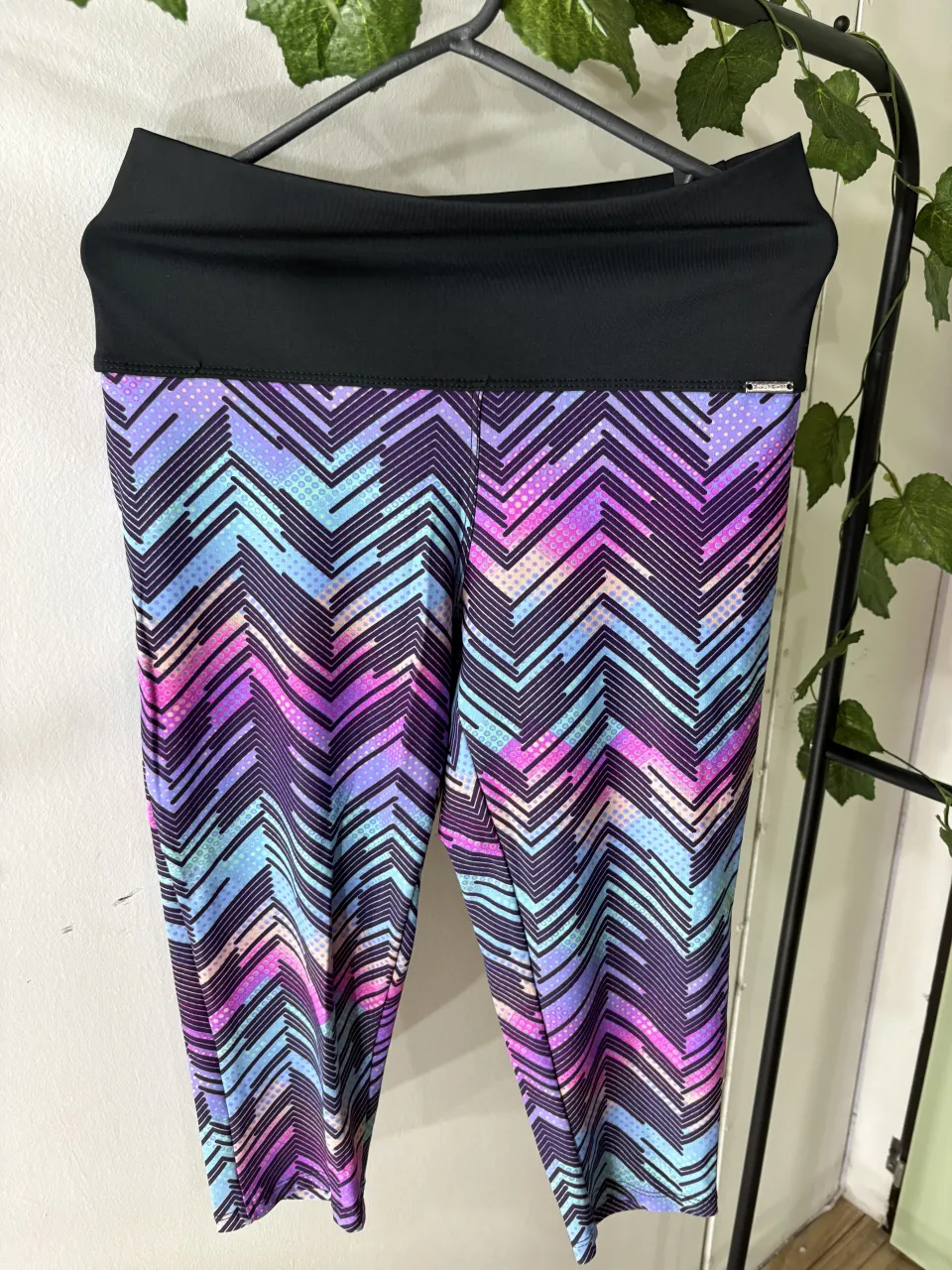 Calzas deportivas estampadas con diseño zig-zag en colores vibrantes. Cintura alta negra para mayor comodidad y ajuste.