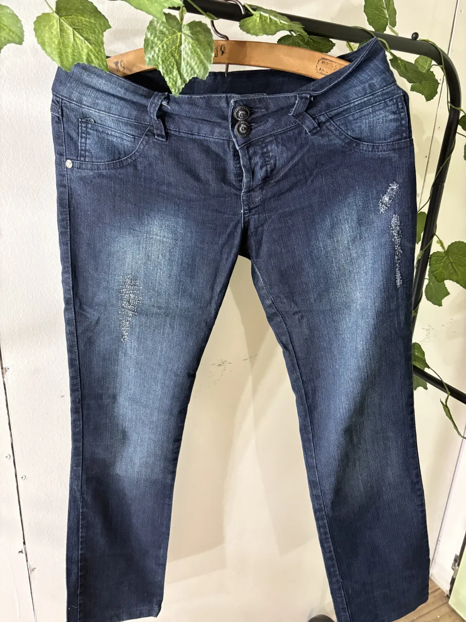Jean azul oscuro con detalles desgastados y roturas sutiles. Tiro medio, corte recto y moderno. Ideal para un look casual y canchero.