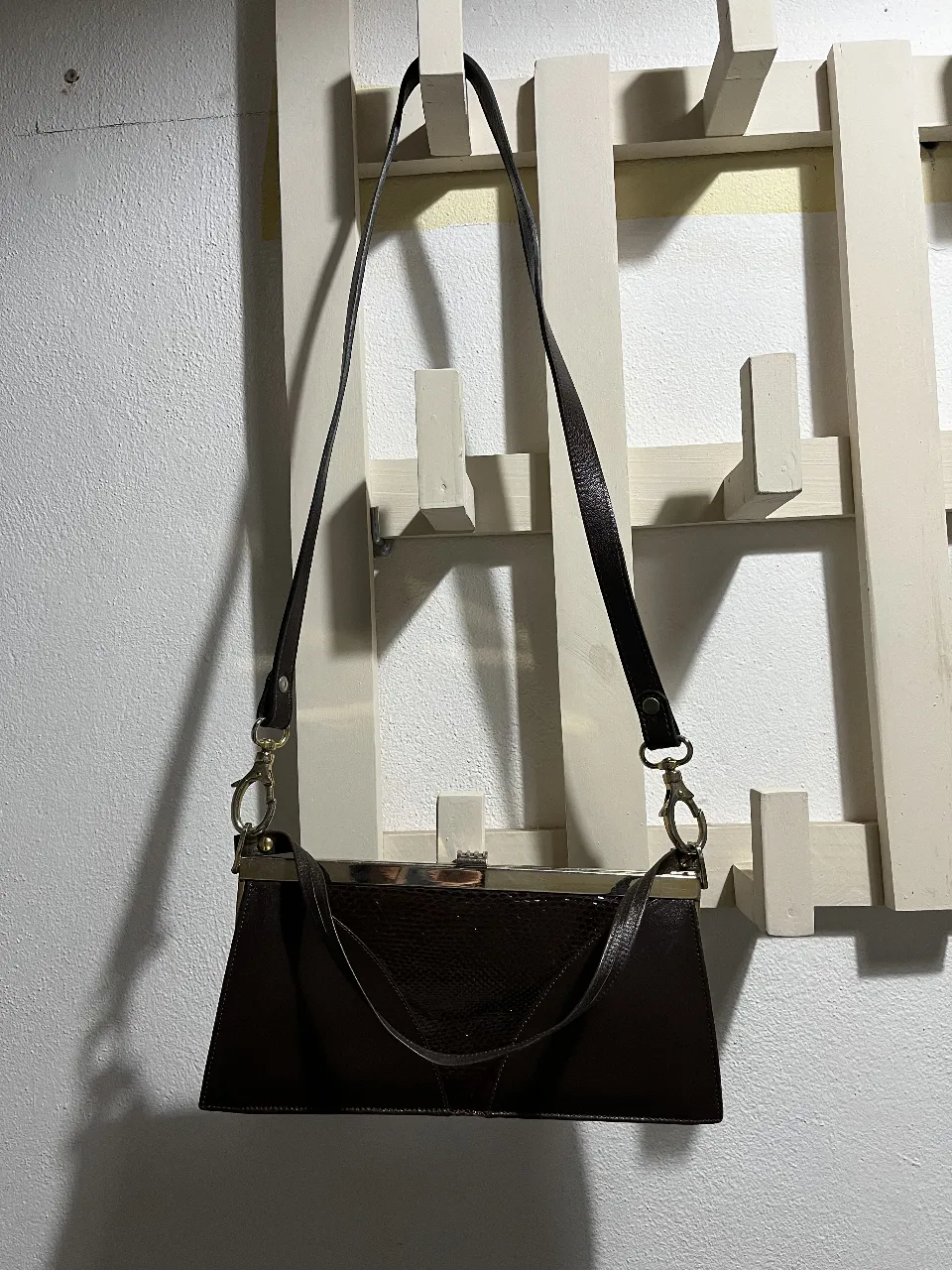 Cartera de cuero vintage marrón oscura. Detalles de  cuero de serpiente real  en la parte frontal. Posee un cierre metálico y una correa larga desmontable. Impecable.