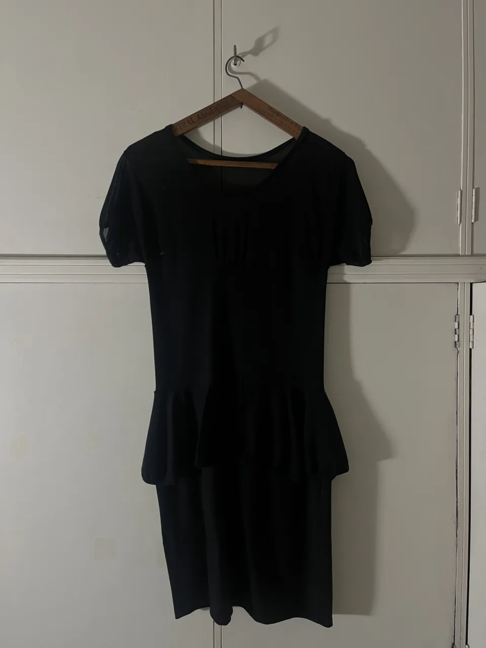 Vestido negro con mangas cortas de tul y falda con volados.