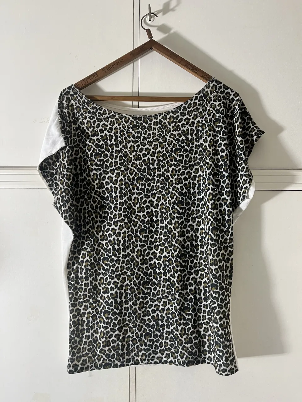 Remera con estampa de leopardo y detalles de strass. Mangas cortas y cuello redondo.