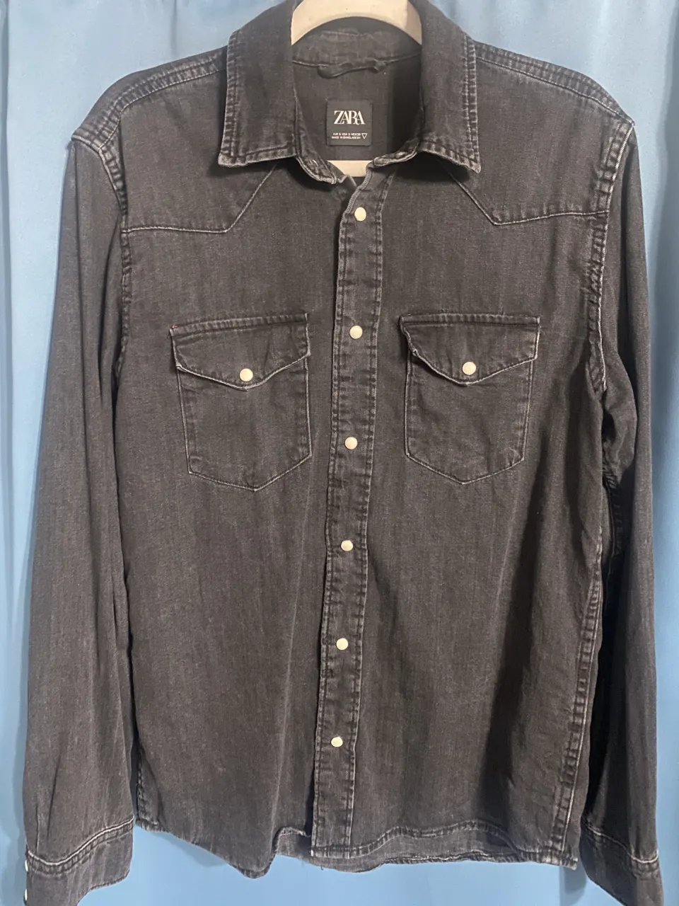 Camisa de jean color negro lavado, manga larga con botones al frente y dos bolsillos en el pecho. excelente estado apenas 2 usos. muy fachera el color es así. 