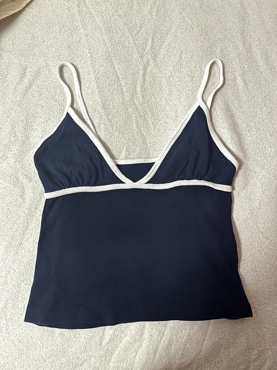 Top de algodón azul marino con vivos blancos en cuello y breteles. Breteles finos.