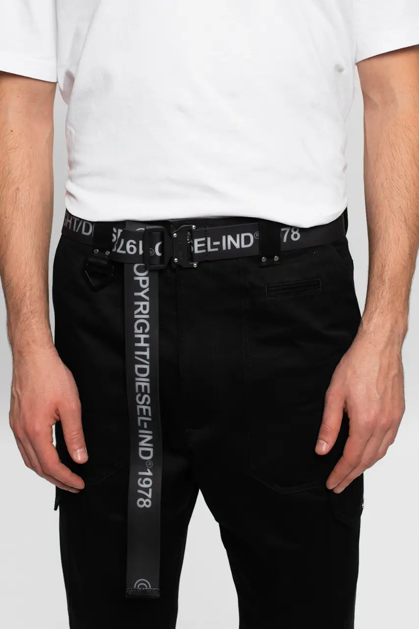 Cinturón Diesel negro con hebilla metálica y logo de la marca. Diseño con inscripción "COPYRIGHT/DIESEL-IND 1978". Ideal para completar cualquier look casual o urbano. medida 95cm. 