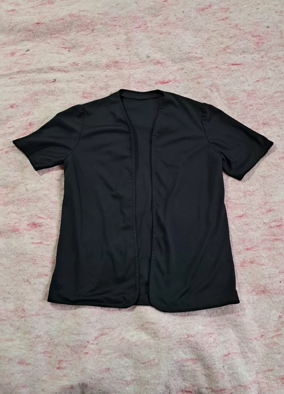 Cardigan negro de manga corta, con cuello redondo y sin abrojo. tela finita tipo calsa 