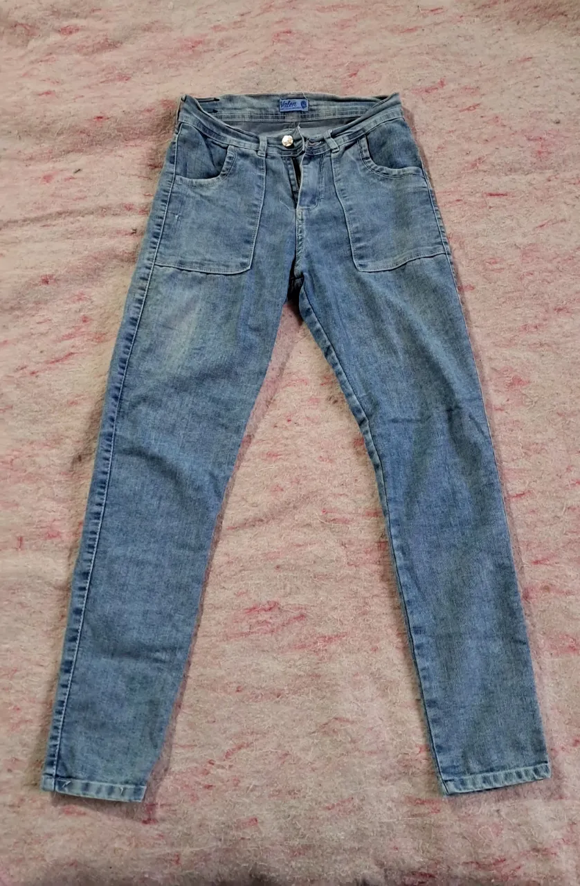 Jean de tiro medio con dos bolsillos delanteros y dos traseros. Cierre y botón en la parte delantera.