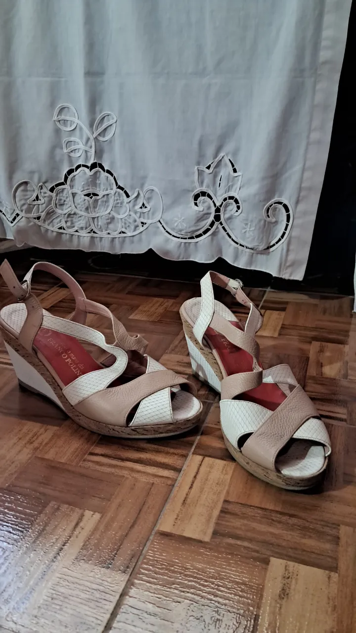 Sandalias con tiras cruzadas en color nude y blanco. Taco cuña con detalles de corcho y blanco. Hebilla para ajuste en el tobillo.