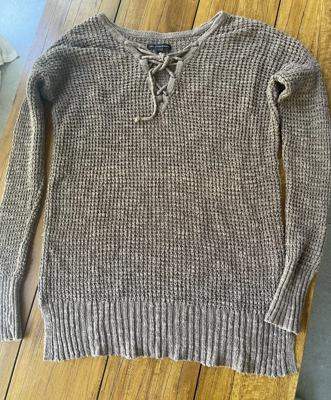 Sweater de tejido rústico con cordones en el escote.