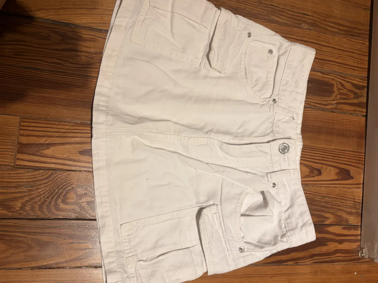 Pollera blanca de jean con bolsillos cargo.