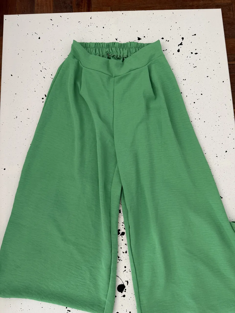 Pantalones anchos de color verde con cintura elastizada y bolsillos.