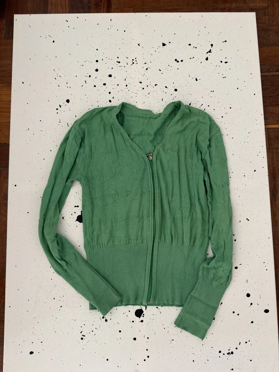 Cardigan verde con cierre al frente y cuello escote en V. Posee puños y cintura de ribb.