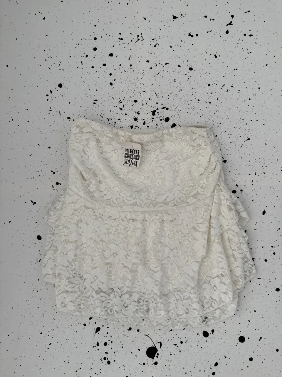 Pollera blanca de encaje con volados en el ruedo.