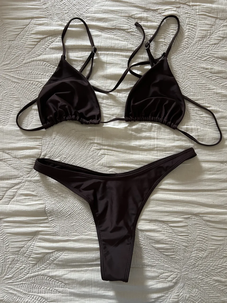 Bikini marrón de dos piezas. El corpiño es triangular con tiras finas regulables y detalles de fruncido en la base. La bombacha es estilo colaless. Solo fue medida, no tiene uso.