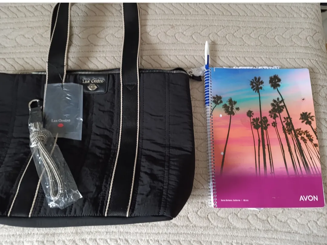 Bolso negro de tela, ideal para el día a día. Tiene detalles en las tiras y un charm colgante. Amplio y práctico para llevar todo lo que necesitás.