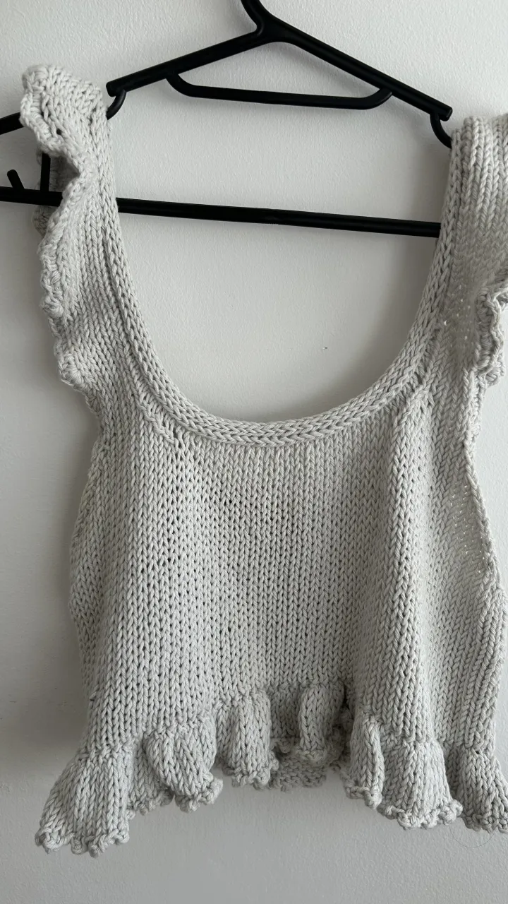 Top tejido de breteles finos con volados en los hombros y en el borde inferior.