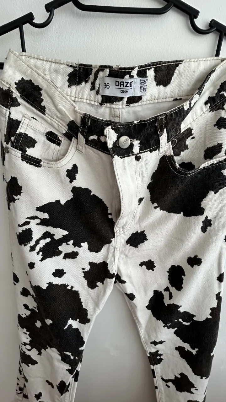 Jeans blancos con estampa de vaca en negro.