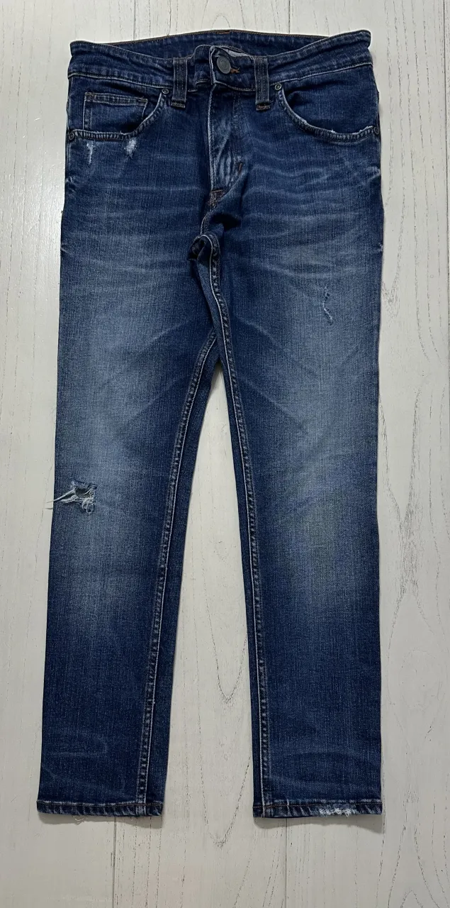 Jeans de corte recto, color azul, con roturas y desgastes.