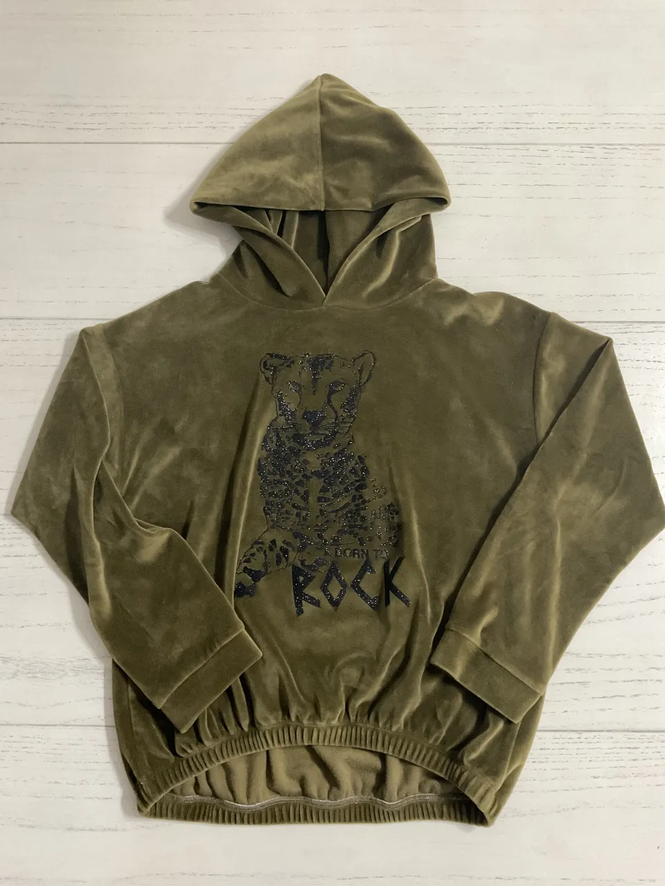 Buzo con capucha de velour color verde militar. Estampado de un guepardo con la frase "Born to Rock". Ideal para un look canchero y cómodo.