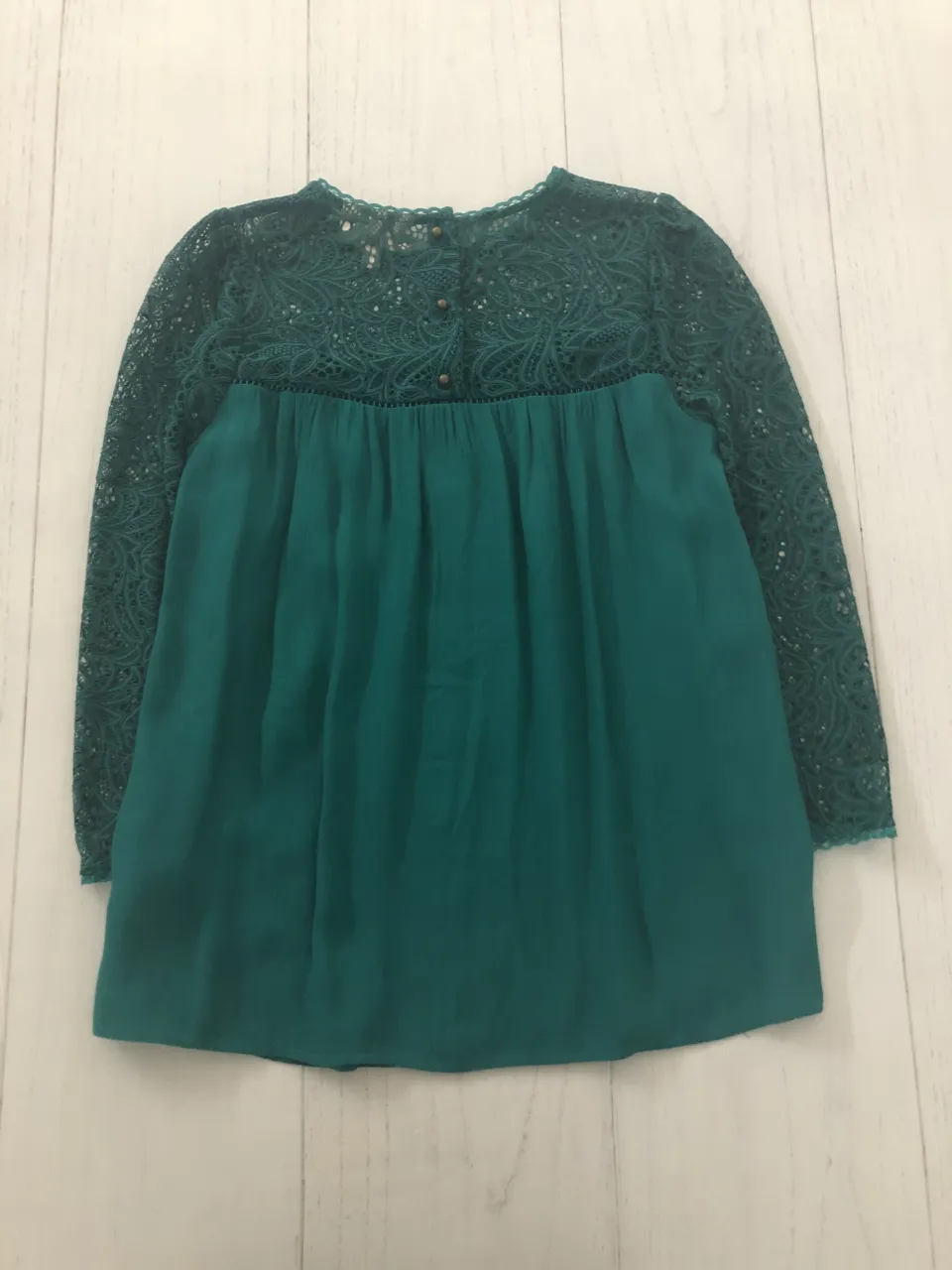 Blusa de encaje verde esmeralda con mangas largas y detalles bordados. Un diseño delicado y elegante, perfecto para ocasiones especiales o para darle un toque sofisticado a tu look.