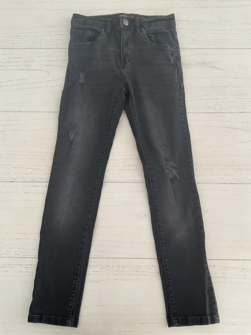 Jeans negros tiro alto con roturas. Un clásico que no puede faltar en tu guardarropa.