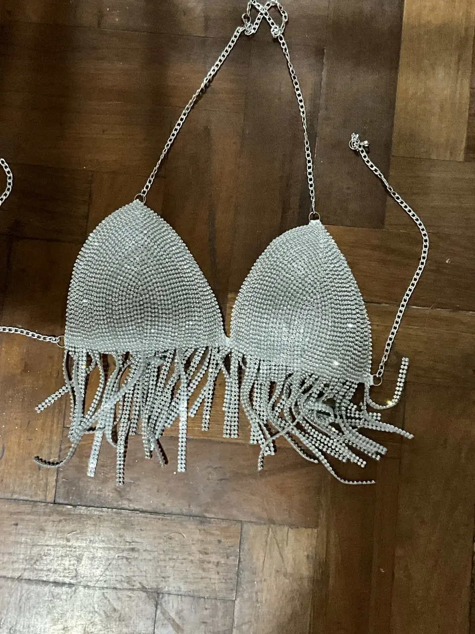 Top de fiesta plateado con flecos, ideal para eventos especiales. Diseño con cadenas y detalles brillantes.