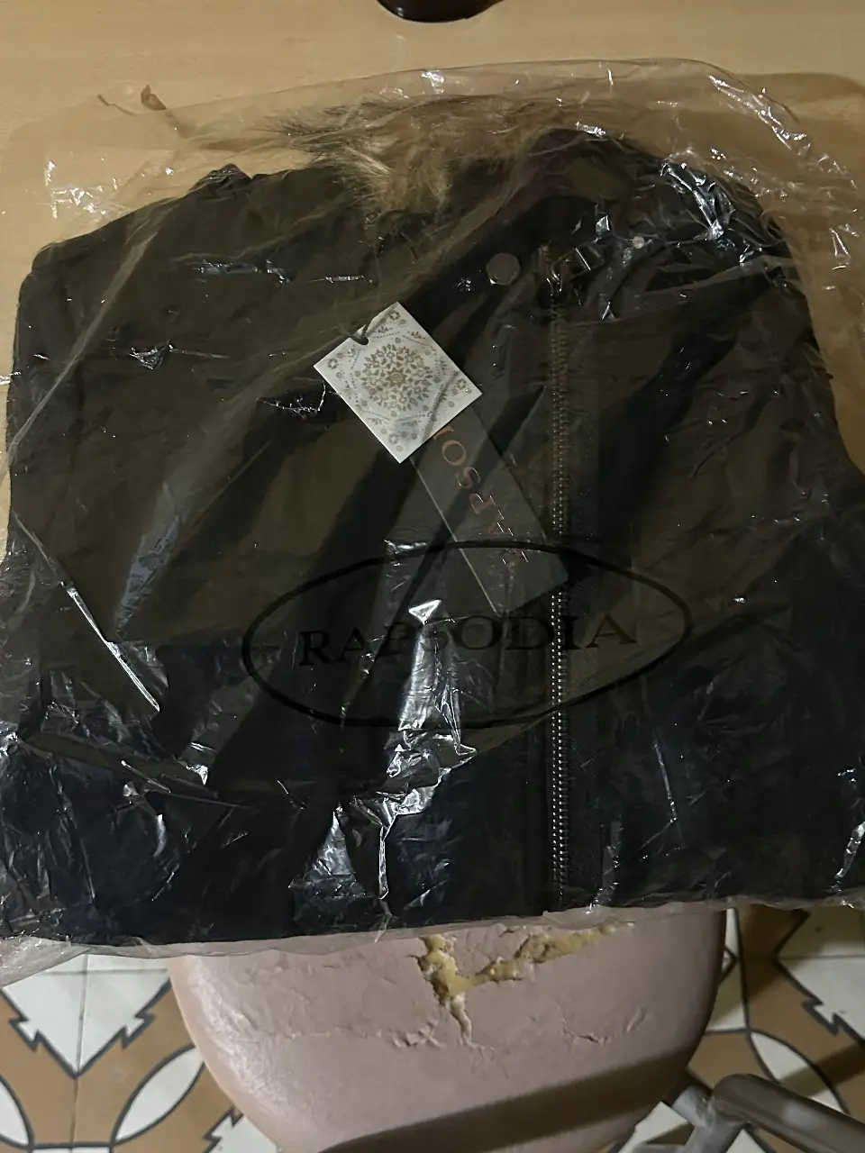 Tapado negro de mujer, con capucha y borde de piel sintética. Posee cierre y detalles de cuero en las mangas. Ideal para el invierno.