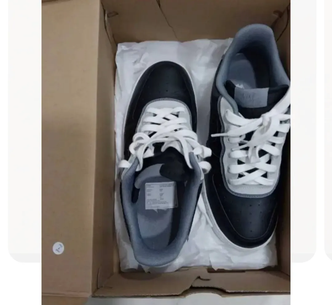 Zapatillas Nike Air Force 1, negras con detalles en blanco y gris. Diseño clásico y atemporal, ideales para un look casual y urbano.