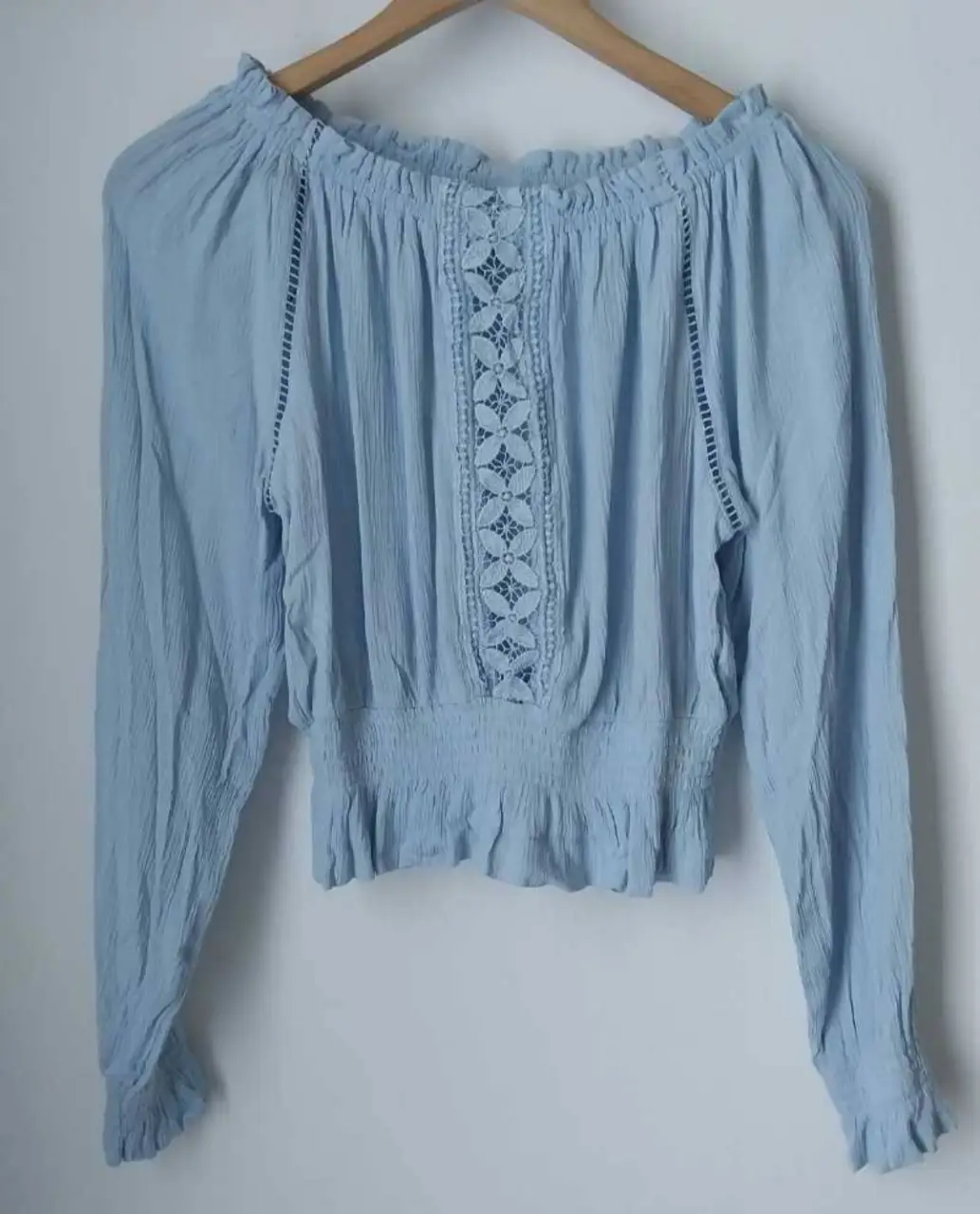 Blusa celeste con detalles de encaje en el centro y en los laterales. Tiene mangas largas y un corte a la cintura con elástico. Ideal para un look bohemio y fresco.Divina,original.las podes encontrar en nuestros vestidores✨️