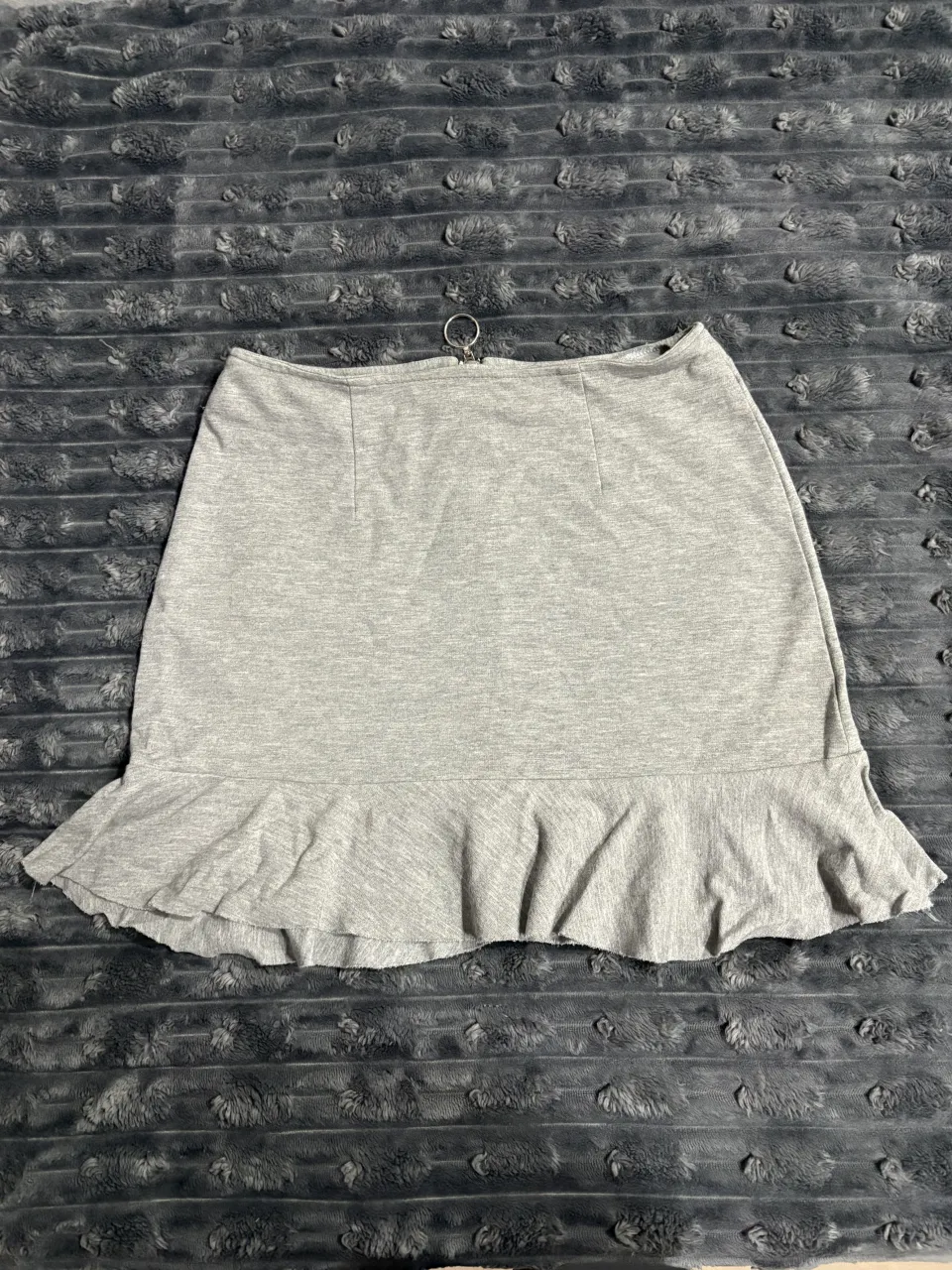 Pollera gris con volado en la parte inferior.