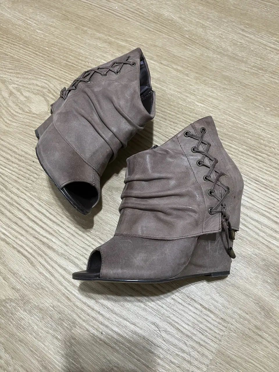 Botas de taco alto con diseño de peep toe y detalles de cordones a los laterales. Impecables.